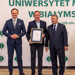 Trzech mężczyzn stoi.