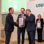 Dyrektor II Liceum Ogólnokształcącego w Białymstoku Piotr Magnuszewski odbiera dyplom z rąk mężczyzny, obok stoi prof. dr hab. n. med. Marcin Moniuszko.