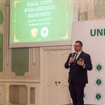 Zastępca prezydenta Tomasz Klim mówi do mikrofonu w tle wyświetlany jest obraz z tekstem „Finał XXVII Podlaskiego Rankingu Liceów i techników, Perspektywy 2025”