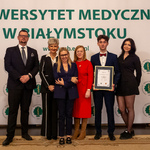 Sześć osób stoi, młody mężczyzna trzyma dyplom.
