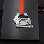 Medal z kształtem maszyny do szycia.