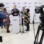 Zastępca prezydenta Rafał Rudnicki mówi do mikrofonu, obok stoją dziennikarze.