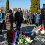 Poseł na Sejm RP stoi z dwiema kobietami pod pomnikiem, w tle inni uczestnicy.