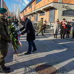 Marszałek Łukasz Prokorym poprawia wstęgę przy kwiatach złożonych przed Pomnikiem Matek Sybiraczek.