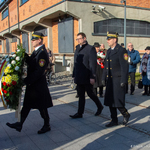 Zastępca prezydenta Tomasz Klim oraz dwóch mundurowych idzie obok budynku Muzeum Pamięci Sybiru.