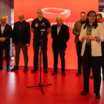 Uczestnicy konferencji stoją obok siebie przed mikrofonami.