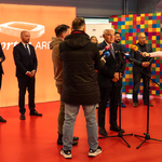 Prezydent Tadeusz Truskolaski mówi do mikrofonu podczas konferencji, w tle stoją inni uczestnicy.