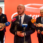 Marszałek Łukasz Prokorym mówi do mikrofonów podczas konferencji.