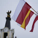 Flagi Polski i Białegostoku na pierwszym planie, w tle fragment Bramy Wielkiej.