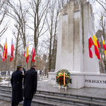 Zastępca prezydenta Rafał Rudnicki oraz funkcjonariusz Straży Miejskiej stoją pod pomnikiem Żołnierzy Polskich.