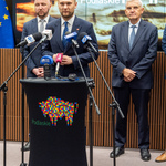 Poseł na Sejm RP mówi do mikrofonów przy mównicy, obok stoi prezydent Tadeusz Truskolaski, zastępca prezydenta Tomasz Klim oraz marszałek Łukasz Prokorym.
