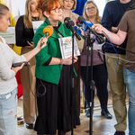 Przedstawicielka organizacji „Droga” mówi do mikrofonów, obok stoją inni uczestnicy.