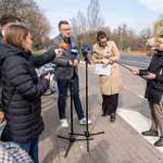 Zastępca prezydenta Rafał Rudnicki udziela wywiadu stojąc przed mikrofonami, obok stoi kilku dziennikarzy.