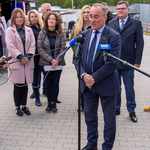 Dyrektor Zarządu Mienia Komunalnego Andrzej Ostrowski udziela wywiadu podczas konferencji prasowej, w tle stoją zastępcy prezydenta i inni uczestnicy.