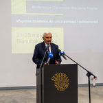 Prezydent Tadeusz Truskolaski mówi do mikrofonu przy mównicy.