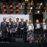 Na scenie stoją nagrodzeni uczestnicy wydarzenia, wśród nich stoi prezydent Tadeusz Truskolaski.