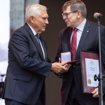 Mężczyzna odbiera nagrodę z rąk prezydenta Tadeusza Truskolaskiego.