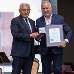 Mężczyzna trzyma nagrodę, obok stoi prezydent Tadeusz Truskolaski.