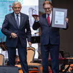 Mężczyzna stoi obok prezydenta Tadeusza Truskolaskiego po otrzymaniu nagrody.