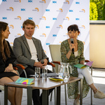 Kobieta mówi do mikrofonu w trakcie konferencji prasowej.