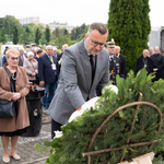 Zastępca prezydenta Rafał Rudnicki poprawia wieniec.