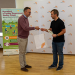 Zastępca prezydenta Rafał Rudnicki wręcza jednemu ze zwycięzców upominek oraz list gratulacyjny.