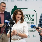 Kobieta mówi do mikrofonu podczas konferencji prasowej.