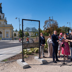 Zastępca prezydenta Rafał Rudnicki mówi do mikrofonów, obok stoją inni uczestnicy oraz dziennikarze, w tle Brama Wielka.