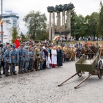 Grupa rekonstruktorów stoi niedaleko wozu, wokół stoją widzowie.