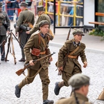 Młodzi rekonstruktorzy biegną podczas inscenizacji.