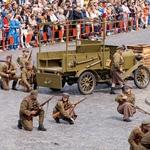 Aktorzy kucają niedaleko wozu podczas rekonstrukcji.