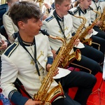 Orkiestra dęta gra na instrumentach podczas uroczystości.