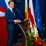 Wojewoda Jacek Brzozowski przemawia do mikrofonu przy mównicy podczas uroczystości.