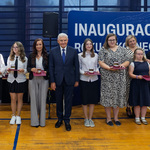 Prezydent Miasta Białegostoku stoi z uczniami nagrodzonymi medalami.
