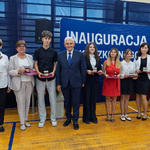 Grupa uczniów i nauczycieli stoi trzymając medale i listy gratulacyjne, wśród nich stoi prezydent Tadeusz Truskolaski.