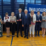 Prezydent Tadeusz Truskolaski oraz grupa uczniów i nauczycieli stoi trzymając medale i listy gratulacyjne.