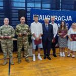 Prezydent Tadeusz Truskolaski stoi z nagrodzonymi medalami.
