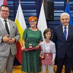 Kobieta i uczennica nagrodzone medalami stoją z dwoma przedstawicielami Miasta.