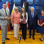 Trzy osoby stoją z przedstawicielami Miasta.