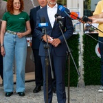 Wojewoda Jacek Brzozowski udziela wywiadu stojąc przed mikrofonami.