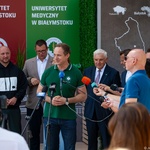 Rektor Uniwersytetu Medycznego w Białymstoku Marcin Moniuszko udziela wywiadu stojąc przed mikrofonami, obok stoją dziennikarze oraz inni uczestnicy.