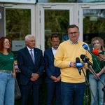 Zastępca prezydenta Rafał Rudnicki stoi przed mikrofonami, w tle stoją inni uczestnicy oraz dziennikarze.