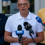 Mężczyzna mówi do mikrofonów podczas konferencji prasowej.