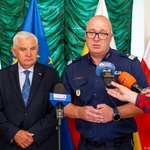 Przedstawiciel policji mówi do mikrofonów które trzymają dziennikarze, obok stoi prezydent Tadeusz Truskolaski.