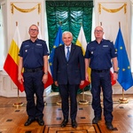 Prezydent Tadeusz Truskolaski stoi obok dwóch funkcjonariuszy policji.