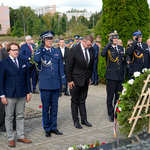Mundurowi, zastępca prezydenta i przedstawiciele instytucji stoją przed pomnikiem.
