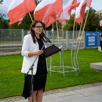 Prowadząca uroczystość mówi do mikrofonu.