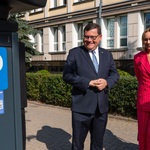 Zastępca prezydenta Marek Masalski oraz kobieta uczestnicząca w konferencji stoją obok parkomatu.