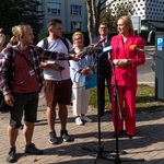 Kobieta udziela wywiadu przed mikrofonami.