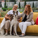 Zastępca prezydenta Eliza Cybulko oraz urzędniczka Eliza Bilewicz-Roszkowska siedzą na żółtej kanapie, obok nich stoi pies.